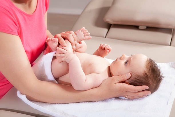 Physiotherapist gently assessing a baby's head and neck position
